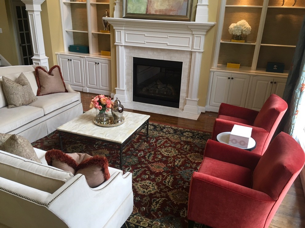Großes, Repräsentatives, Fernseherloses, Offenes Klassisches Wohnzimmer mit gelber Wandfarbe, braunem Holzboden, Kamin, Kaminumrandung aus Holz und braunem Boden in Louisville