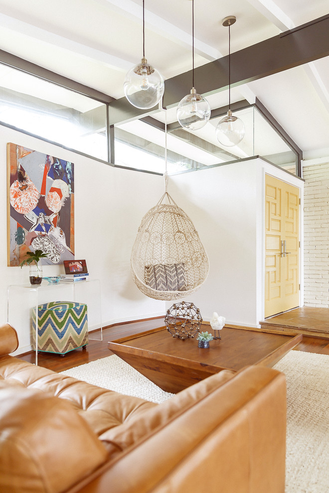 Immagine di un grande soggiorno moderno aperto con pareti bianche, parquet scuro, TV a parete e pavimento marrone