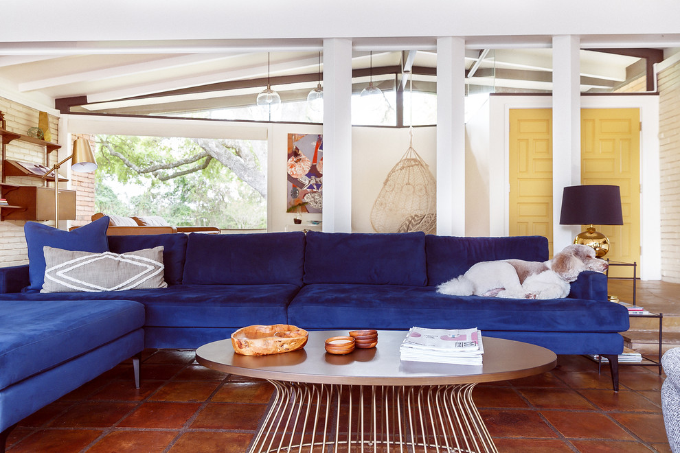 Immagine di un grande soggiorno minimalista aperto con pareti bianche, pavimento in terracotta e pavimento marrone