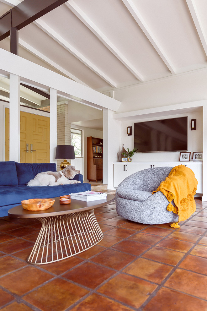 Foto di un grande soggiorno moderno aperto con pareti bianche, pavimento in terracotta, TV a parete e pavimento marrone