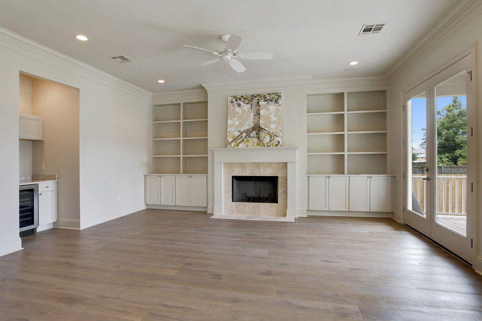 Large elegant open concept living room library photo in New Orleans with white walls, a standard fireplace and a tile fireplace