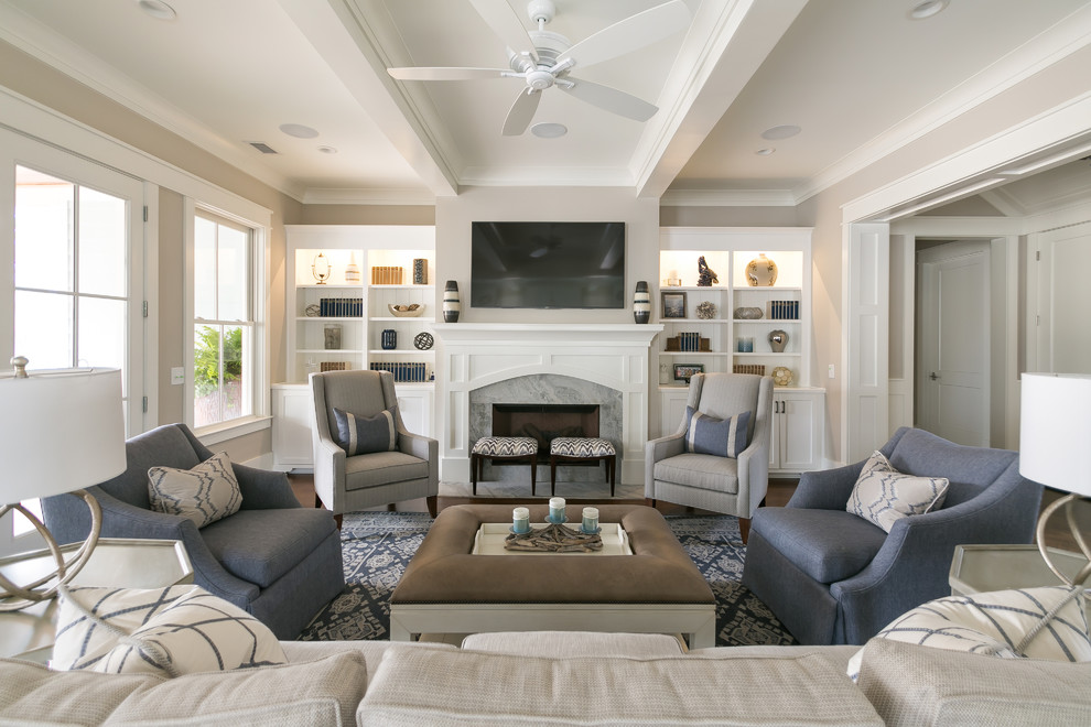 This is an example of a nautical open plan living room in Charleston with beige walls, medium hardwood flooring, a standard fireplace, a stone fireplace surround, a wall mounted tv and brown floors.