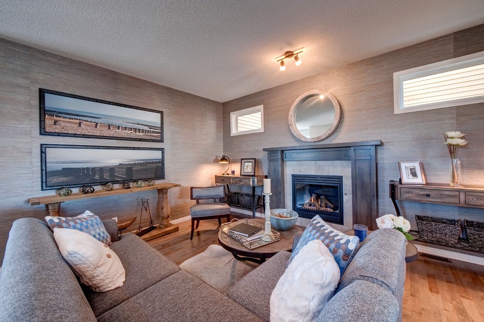 Cette image montre un salon design ouvert avec un mur multicolore, parquet clair, une cheminée standard et un manteau de cheminée en carrelage.