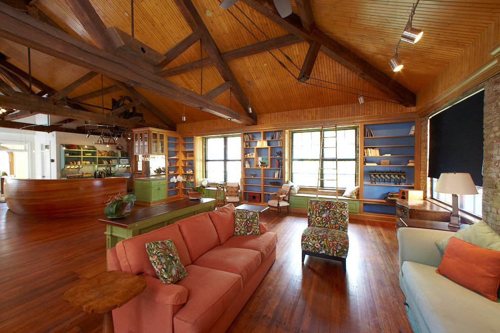 Modelo de salón abierto de estilo de casa de campo grande sin televisor con suelo de madera en tonos medios