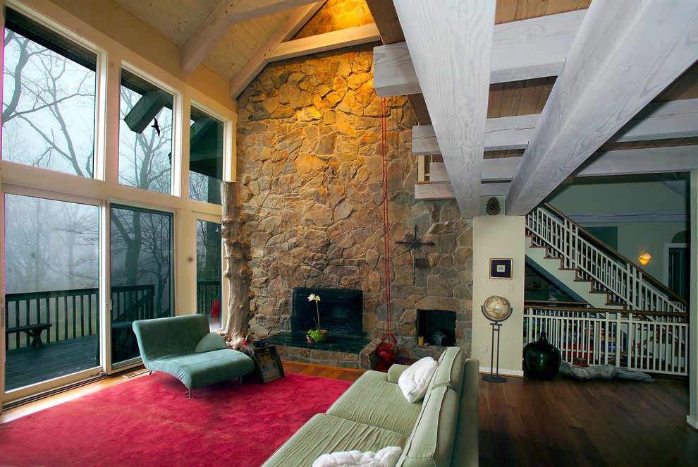 Cette photo montre un salon tendance avec un manteau de cheminée en pierre et un mur en pierre.