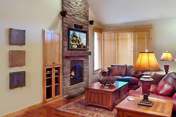Inspiration for a small country open concept medium tone wood floor living room remodel in Other with beige walls, a standard fireplace, a stone fireplace and a wall-mounted tv