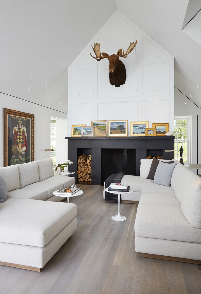 Imagen de salón abierto contemporáneo grande con paredes blancas, suelo de madera en tonos medios, todas las chimeneas, marco de chimenea de piedra y suelo marrón