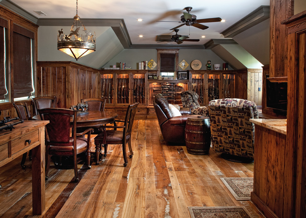 Cette image montre un salon traditionnel de taille moyenne avec un bar de salon, un mur vert, un sol en bois brun, aucune cheminée et un téléviseur fixé au mur.
