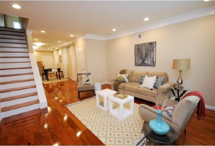 Classic open plan living room in Philadelphia with beige walls and medium hardwood flooring.