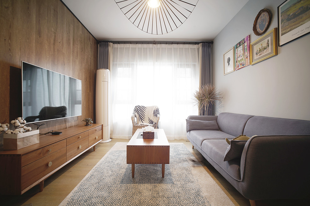 Foto de salón para visitas cerrado escandinavo pequeño sin chimenea con paredes amarillas, suelo de madera en tonos medios, televisor colgado en la pared y suelo amarillo