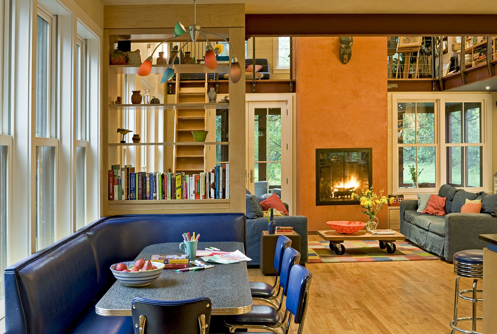 Cette image montre un salon design ouvert avec un mur orange et une cheminée standard.
