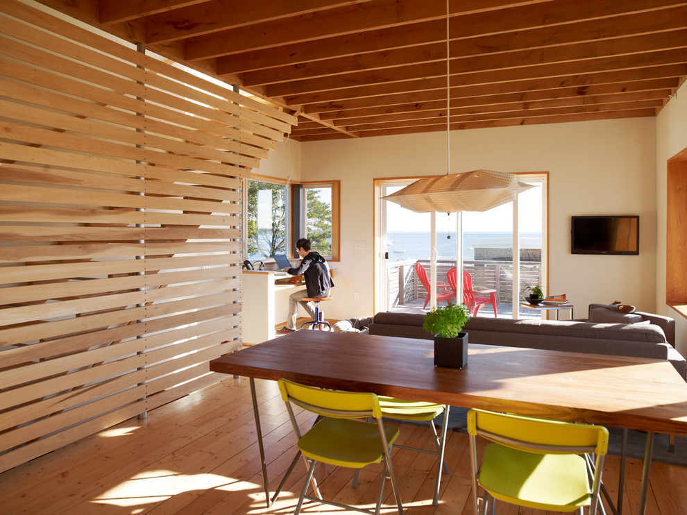 Foto di un soggiorno classico aperto con pareti beige, pavimento in legno massello medio e TV a parete