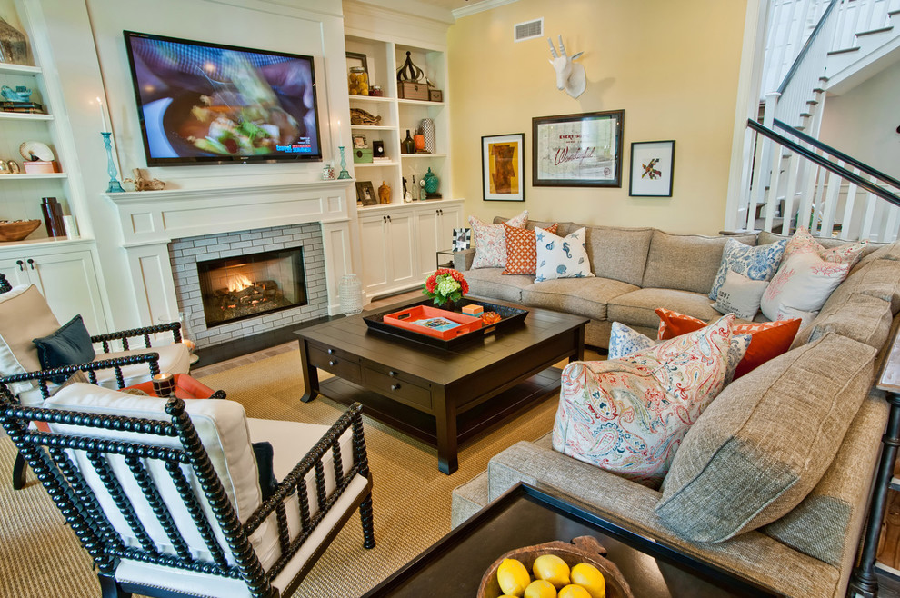 Example of a trendy living room design in Los Angeles with yellow walls, a standard fireplace and a brick fireplace