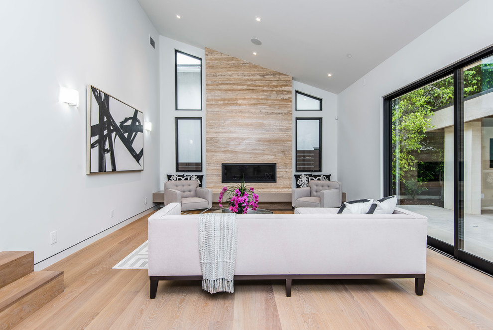 Großes, Repräsentatives, Abgetrenntes Modernes Wohnzimmer mit weißer Wandfarbe, hellem Holzboden, Gaskamin und Kaminumrandung aus Stein in Los Angeles