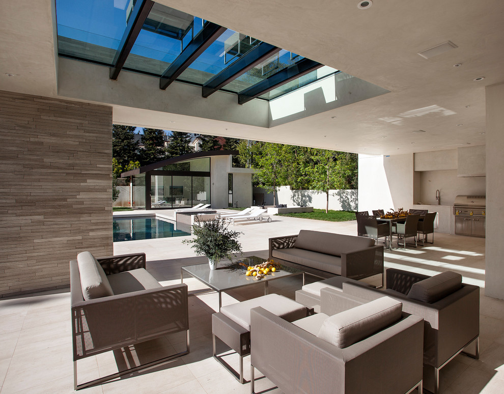 This is an example of a large contemporary open plan living room in Los Angeles with white walls, concrete flooring and white floors.