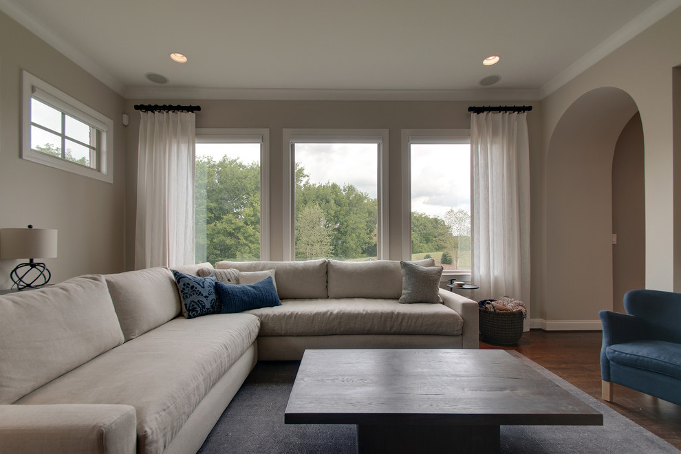 Пример оригинального дизайна: гостиная комната среднего размера в стиле ретро с серыми стенами, темным паркетным полом, стандартным камином, фасадом камина из дерева и коричневым полом