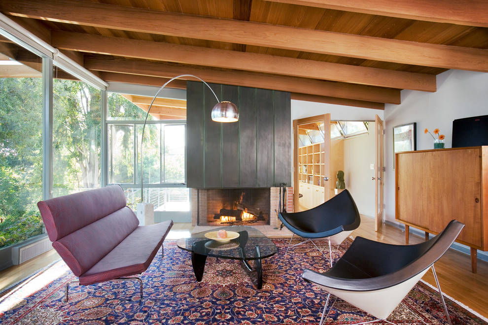 Repräsentatives, Abgetrenntes Modernes Wohnzimmer mit weißer Wandfarbe, braunem Holzboden und Kaminumrandung aus Backstein in Los Angeles