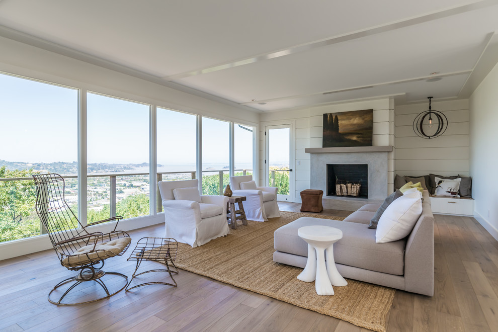Offenes Maritimes Wohnzimmer mit weißer Wandfarbe, braunem Holzboden, Kamin und braunem Boden in San Francisco