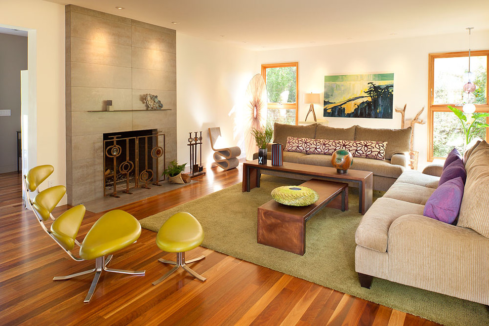 Example of a large trendy formal and enclosed medium tone wood floor and brown floor living room design in San Francisco with a standard fireplace, beige walls and no tv