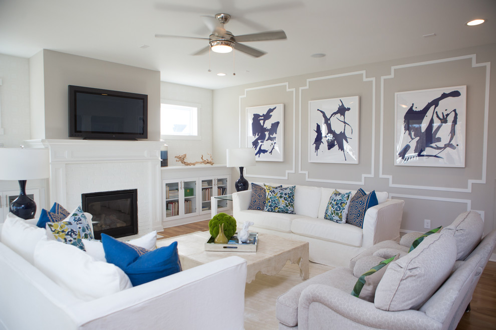 Immagine di un soggiorno tradizionale aperto con pareti beige, parquet chiaro, camino classico e TV a parete