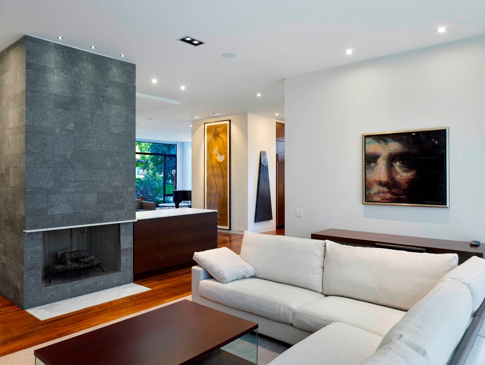 Стильный дизайн: открытая, парадная гостиная комната среднего размера в современном стиле с белыми стенами, паркетным полом среднего тона, стандартным камином и фасадом камина из камня - последний тренд