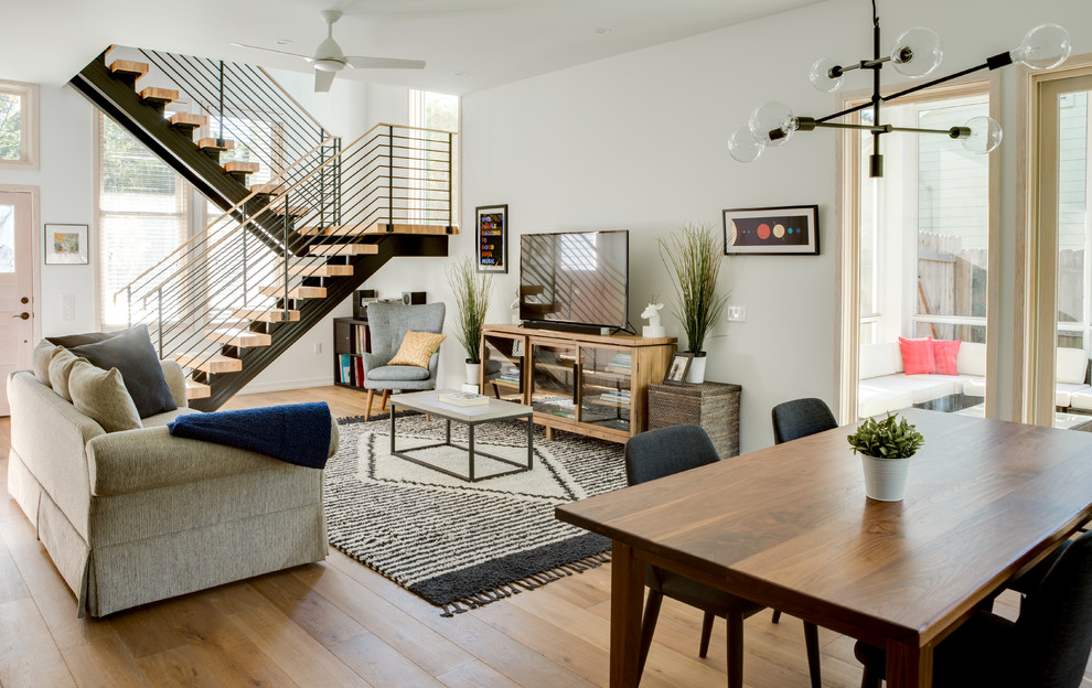 Inspiration for a classic open plan living room in Austin with white walls, a freestanding tv, brown floors and medium hardwood flooring.