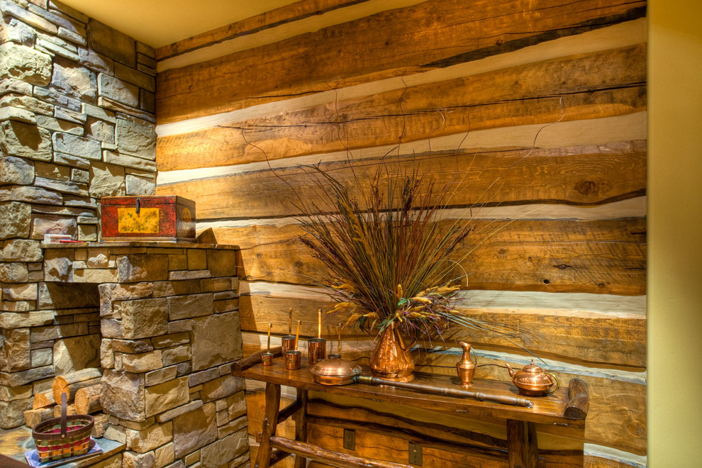 Inspiration för mellanstora rustika vardagsrum, med mellanmörkt trägolv, bruna väggar, en standard öppen spis och en spiselkrans i sten