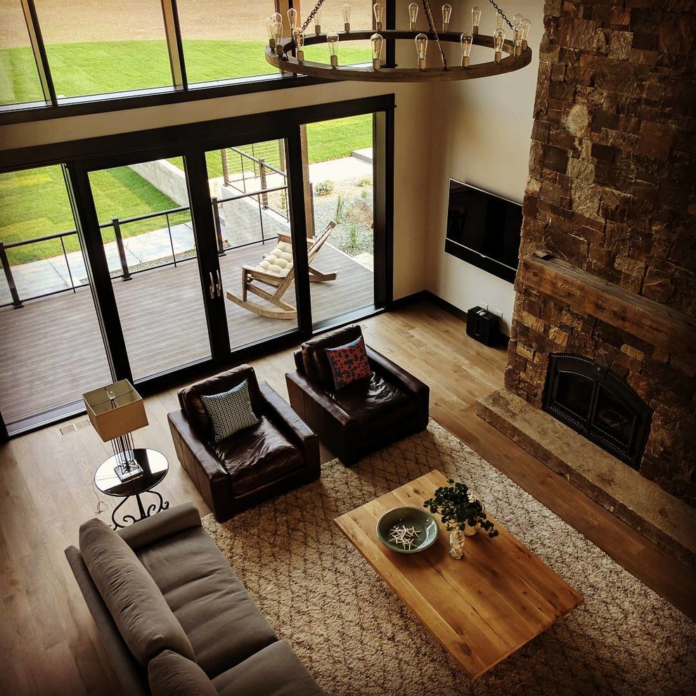 Design ideas for a large rustic open plan living room in Other with beige walls, a stone fireplace surround, a wall mounted tv, brown floors, dark hardwood flooring and a standard fireplace.