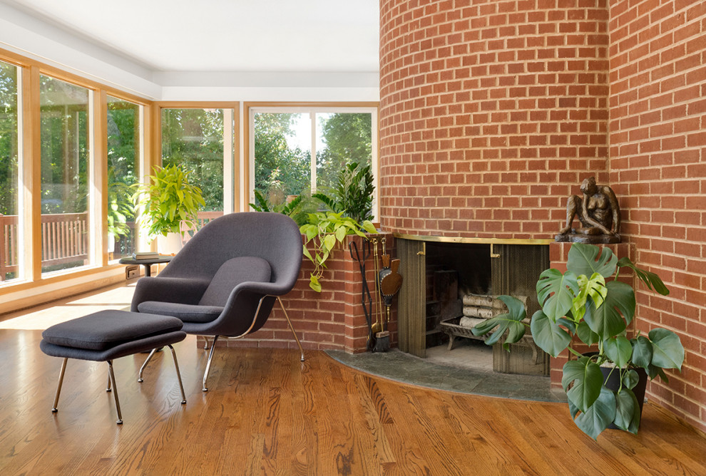 Inspiration for a large midcentury open plan living room in Portland with white walls, medium hardwood flooring, a brick fireplace surround and brown floors.