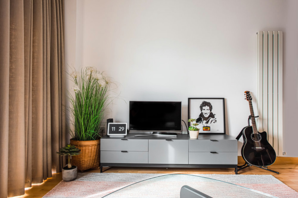 Imagen de salón abierto contemporáneo pequeño con suelo de madera en tonos medios y televisor independiente