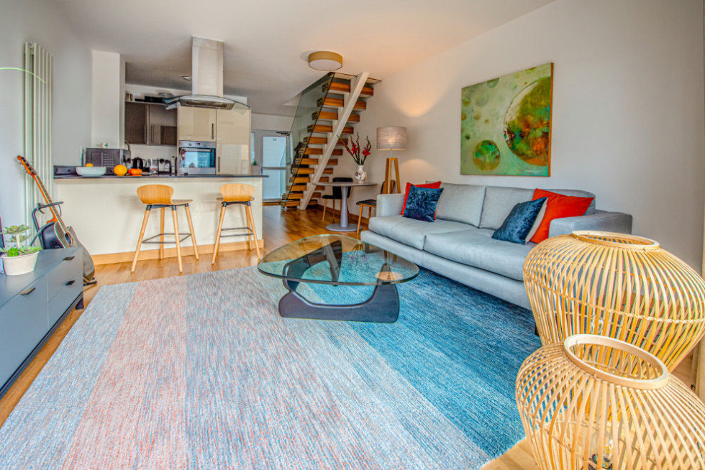 Idee per un piccolo soggiorno scandinavo aperto con pavimento in legno massello medio e TV autoportante