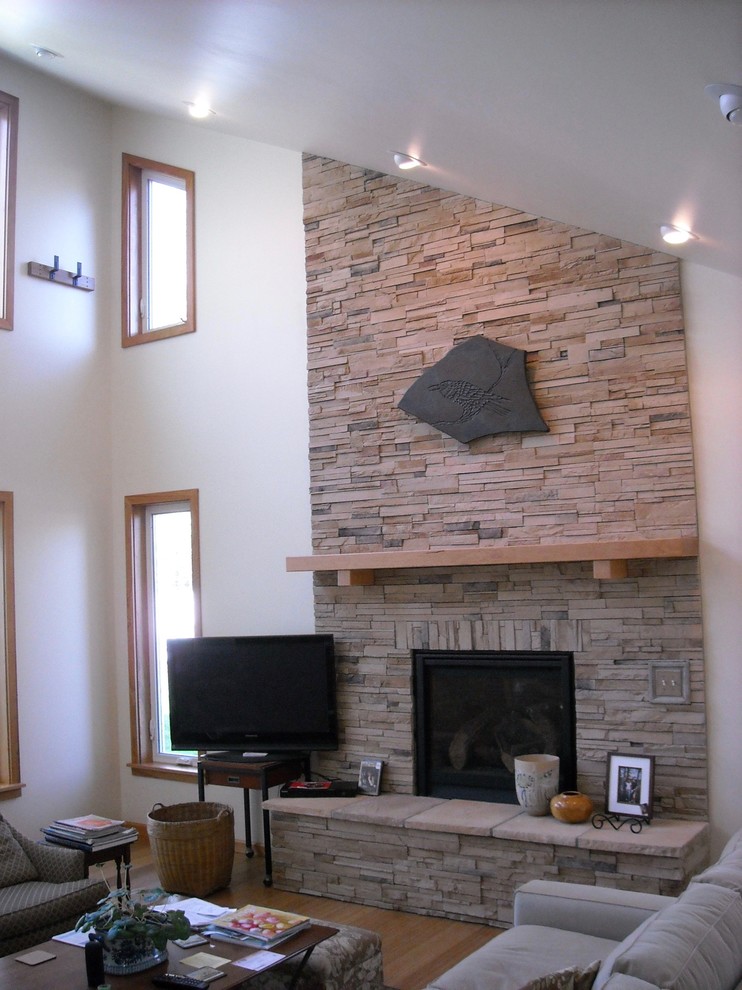 Foto de salón abierto de estilo americano de tamaño medio con paredes blancas, suelo de madera clara, todas las chimeneas, marco de chimenea de piedra y televisor independiente