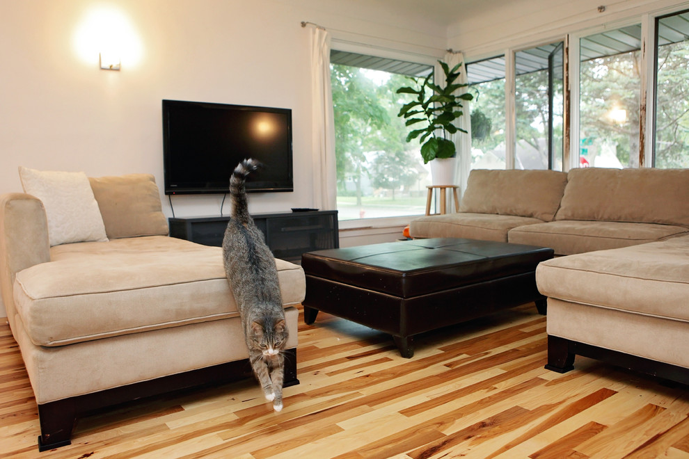 Mittelgroßes, Offenes Modernes Wohnzimmer mit weißer Wandfarbe, braunem Holzboden, Kamin, Kaminumrandung aus Stein und TV-Wand in Minneapolis