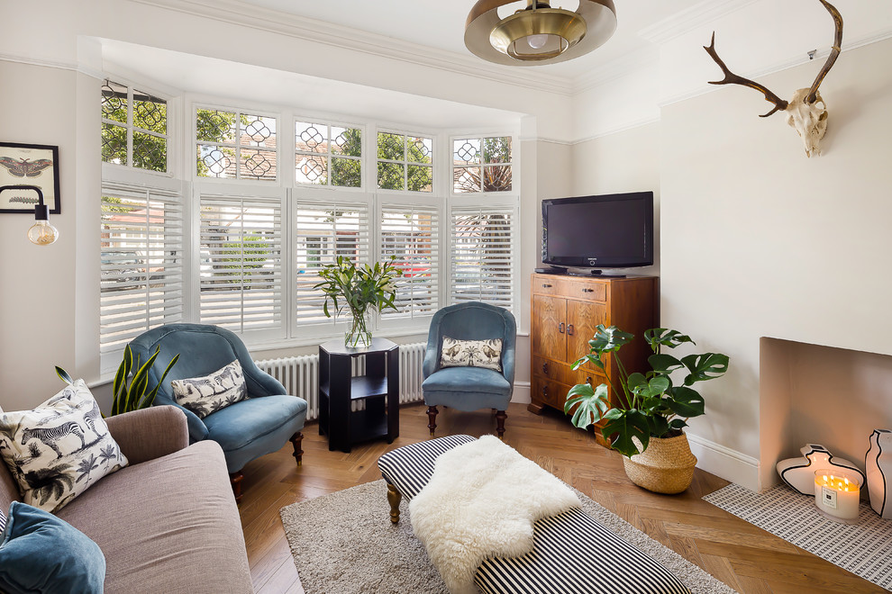 Repräsentatives Klassisches Wohnzimmer mit beiger Wandfarbe, braunem Holzboden, freistehendem TV und braunem Boden in London