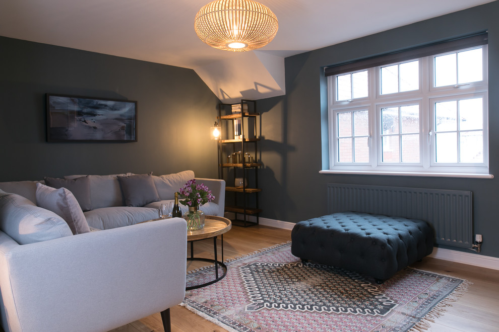 Medium sized contemporary grey and teal open plan living room in Other with a reading nook, blue walls, medium hardwood flooring, a freestanding tv and brown floors.