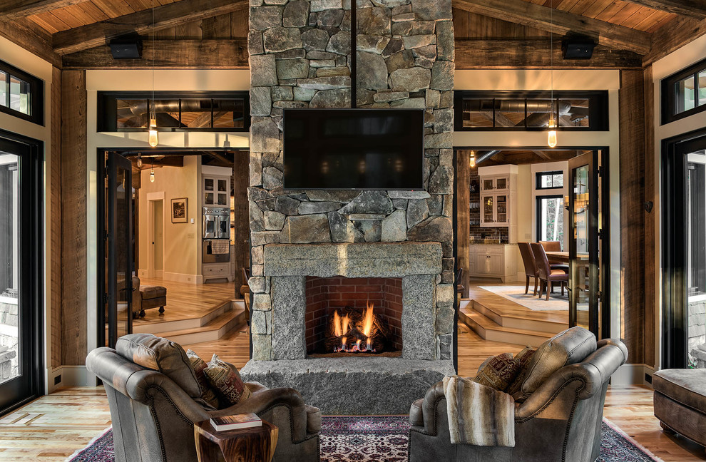 This is an example of a rustic living room in Boston with beige walls, medium hardwood flooring, a standard fireplace and a stone fireplace surround.