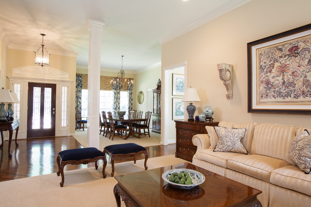 Großes, Repräsentatives, Offenes Klassisches Wohnzimmer mit beiger Wandfarbe, braunem Holzboden, Kamin und Kaminumrandung aus Holz in Houston
