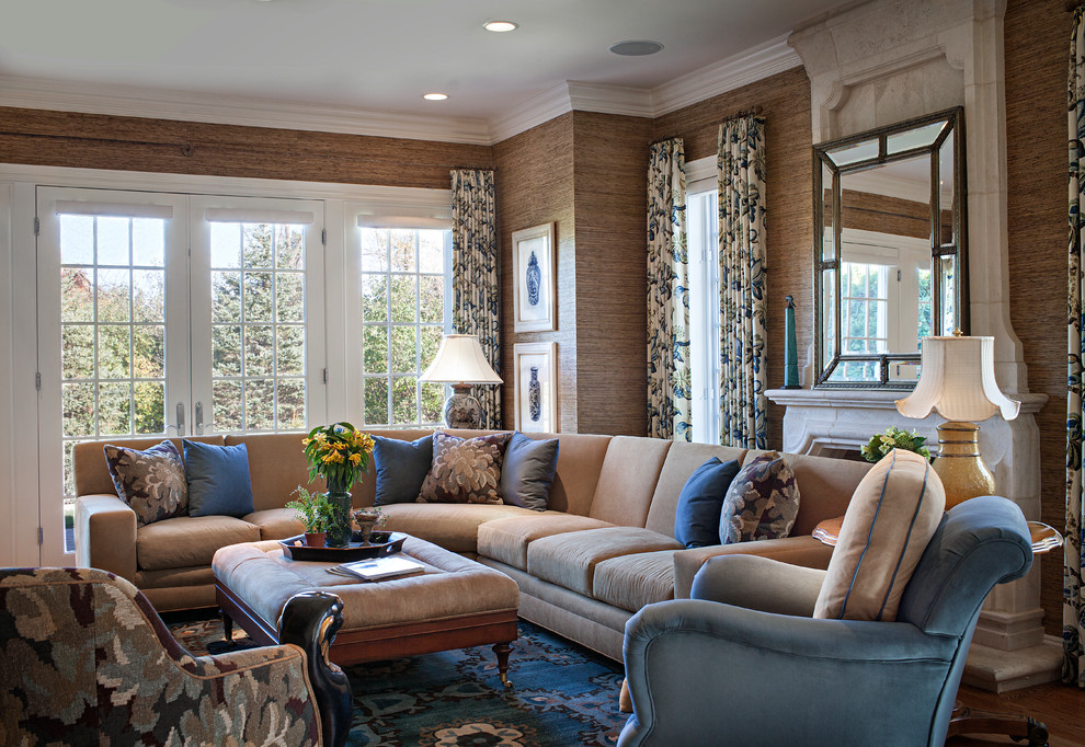 На фото: гостиная комната в классическом стиле с коричневыми стенами, паркетным полом среднего тона и стандартным камином