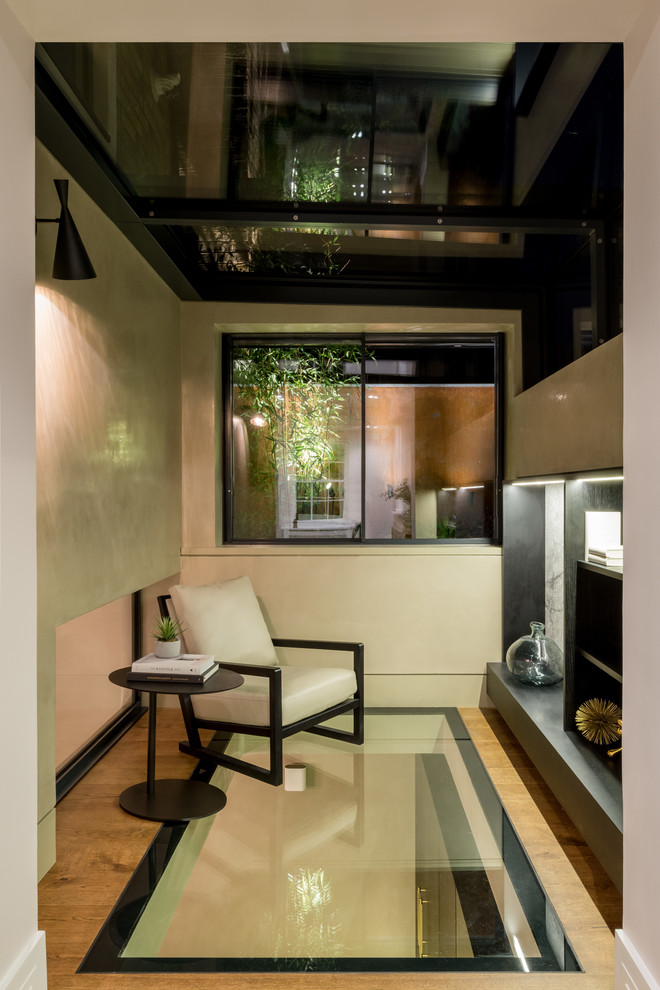 Идея дизайна: гостиная комната в современном стиле с белыми стенами, полом из фанеры и коричневым полом