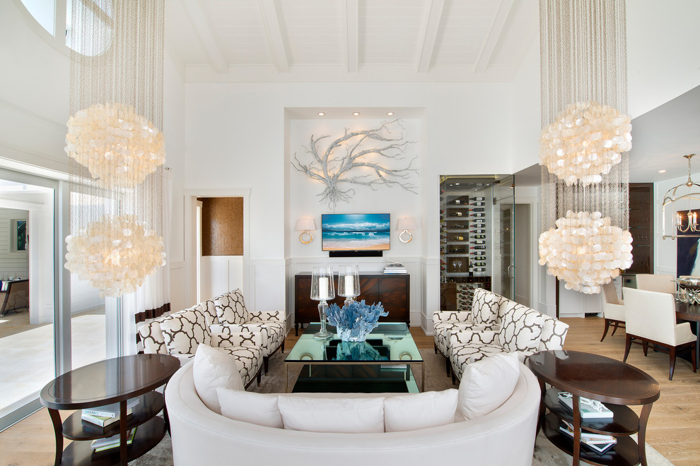 Offenes Modernes Wohnzimmer ohne Kamin mit weißer Wandfarbe, hellem Holzboden und TV-Wand in Sonstige