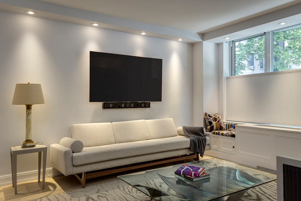 Modelo de salón abierto clásico renovado de tamaño medio sin chimenea con paredes blancas, suelo de madera clara, televisor colgado en la pared y suelo beige
