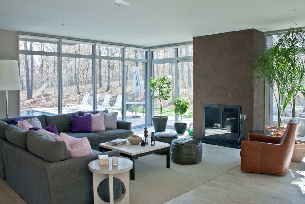 Идея дизайна: большая открытая гостиная комната в современном стиле с серыми стенами, полом из керамогранита, печью-буржуйкой, фасадом камина из камня и телевизором на стене