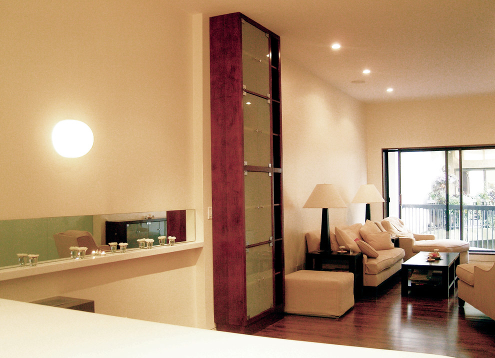Foto på ett funkis vardagsrum, med mellanmörkt trägolv och en väggmonterad TV