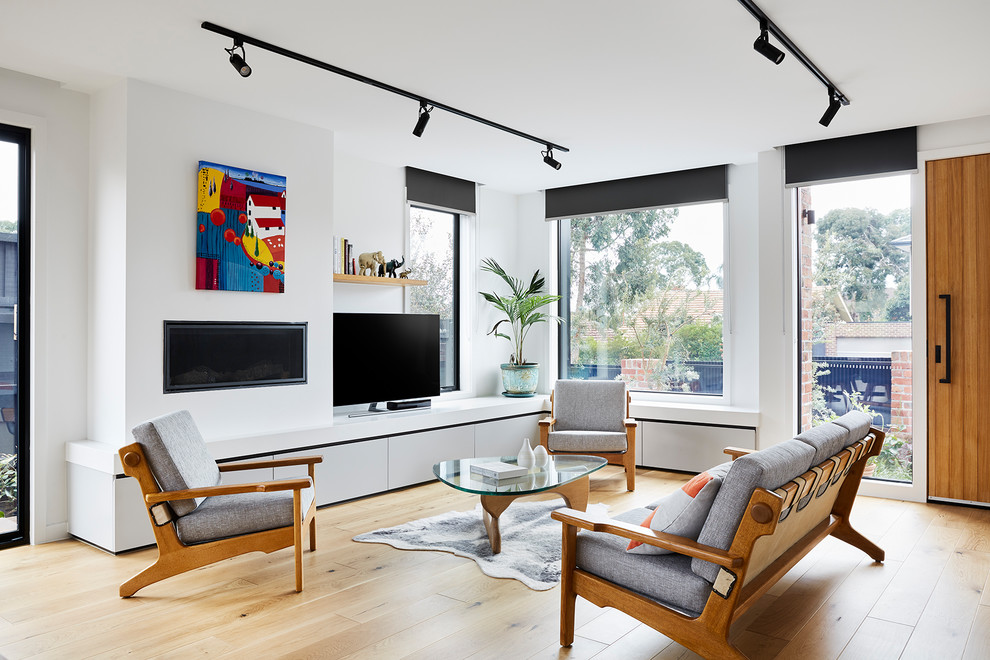 На фото: открытая гостиная комната среднего размера в современном стиле с светлым паркетным полом, фасадом камина из штукатурки, отдельно стоящим телевизором, белыми стенами, горизонтальным камином и коричневым полом