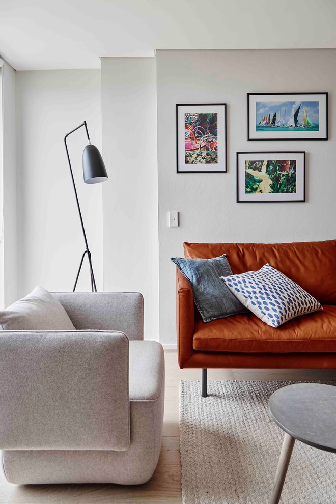 Immagine di un piccolo soggiorno design aperto con pareti grigie, parquet chiaro e pavimento beige