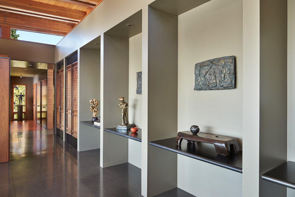 Idée de décoration pour un salon design ouvert avec un mur gris.