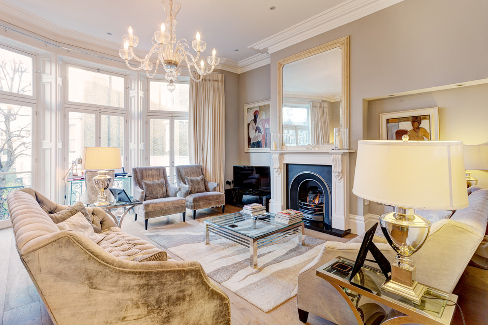 Inspiration for a classic living room in London with beige walls, light hardwood flooring, a standard fireplace and no tv.