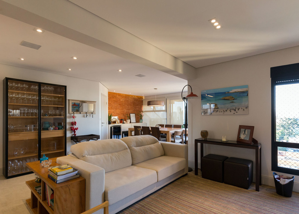 Immagine di un soggiorno design di medie dimensioni e stile loft con pareti grigie, pavimento in gres porcellanato, TV a parete e pavimento grigio