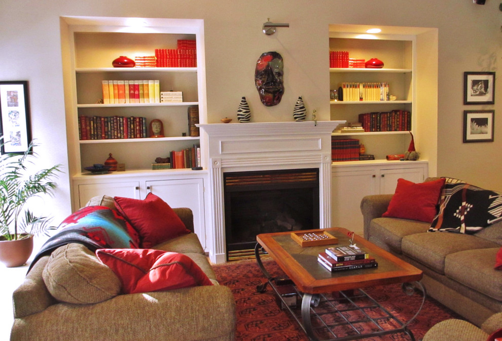 Ejemplo de biblioteca en casa cerrada tradicional de tamaño medio con paredes beige, moqueta, todas las chimeneas, marco de chimenea de madera y suelo rojo