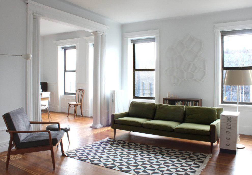 Inspiration for a modern living room in New York with white walls and feature lighting.